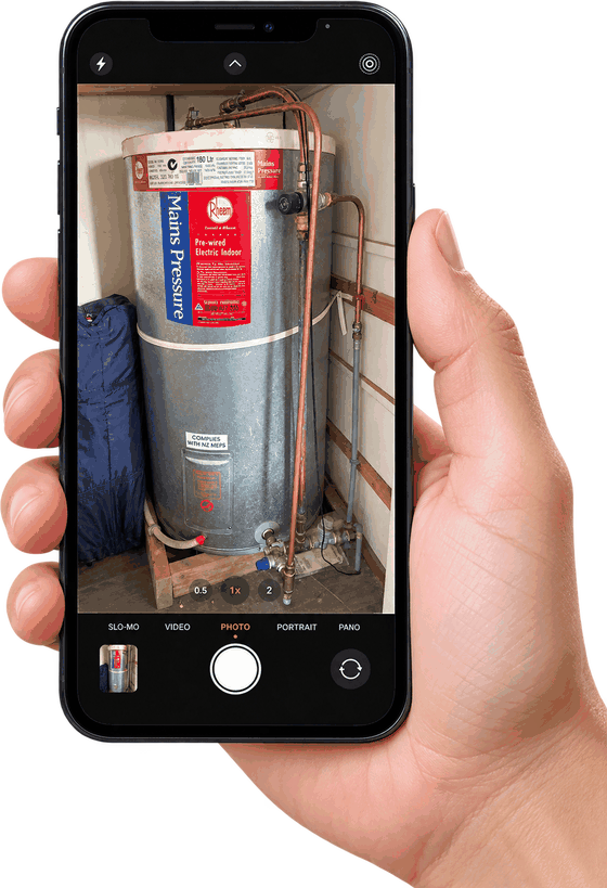 A phone photographing the data plate on a hot water cylinder
